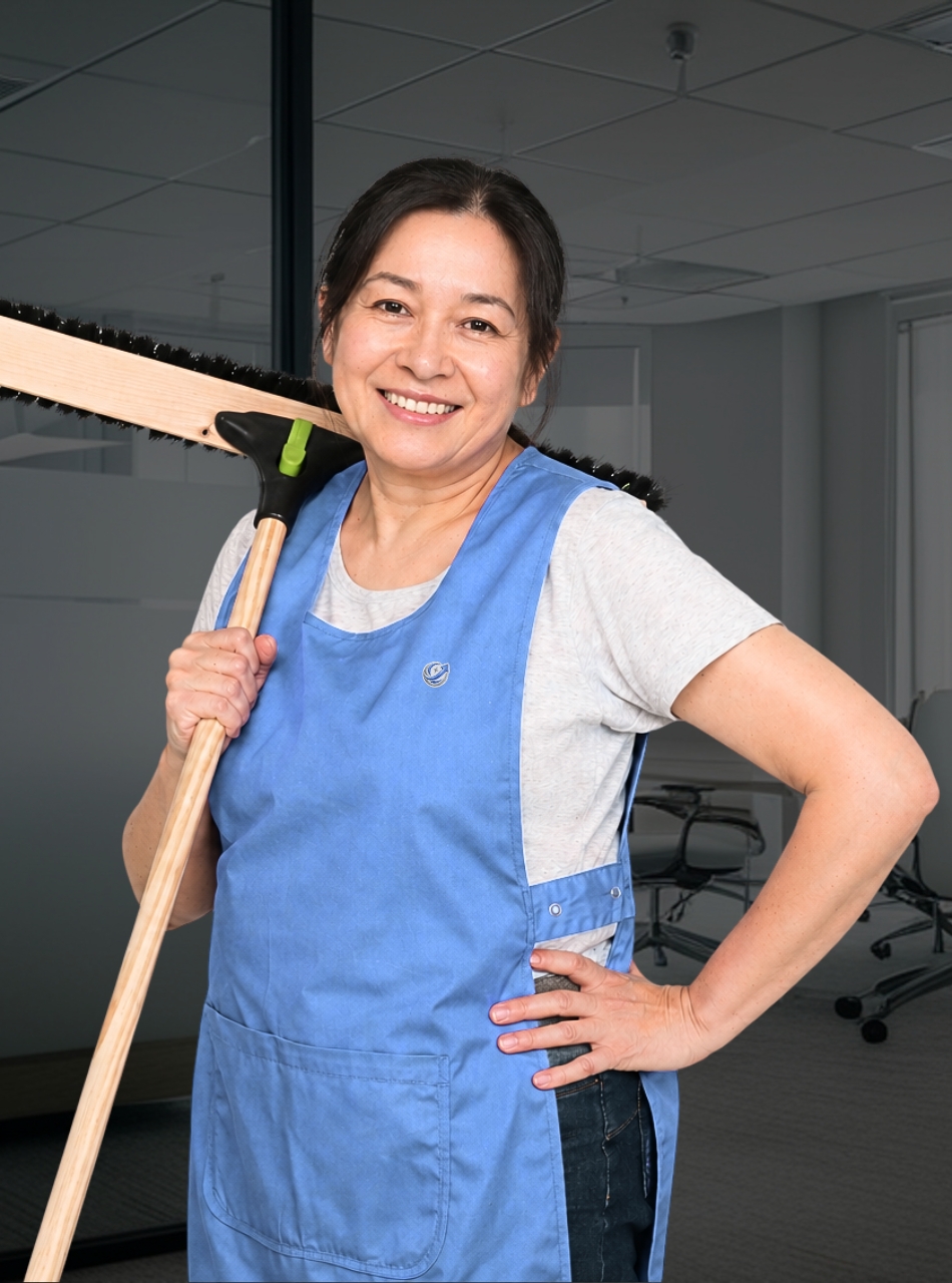 Reinigungskraft von UpClean Gebäudereinigung bei der Büroreinigung in Stuttgart mit Besen