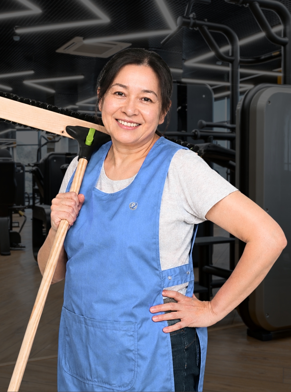 Reinigungskraft von UpClean Gebäudereinigung bei der Fitnessstudio-Reinigung in Stuttgart mit Besen